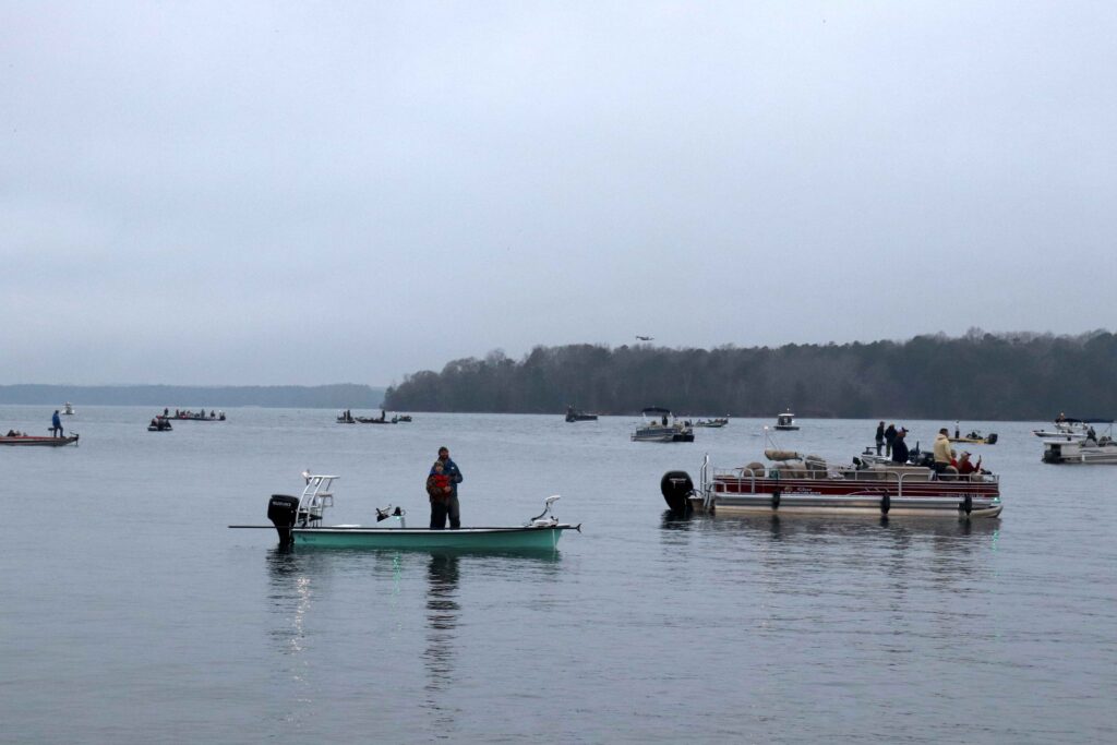 Father and son fly a drone from their boat while waiting for the Bassmaster Classic takeoff on Lake Hartwell